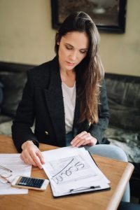 woman sitting at a desk, looking at paper work confused as the paper has scam written in permanent marker